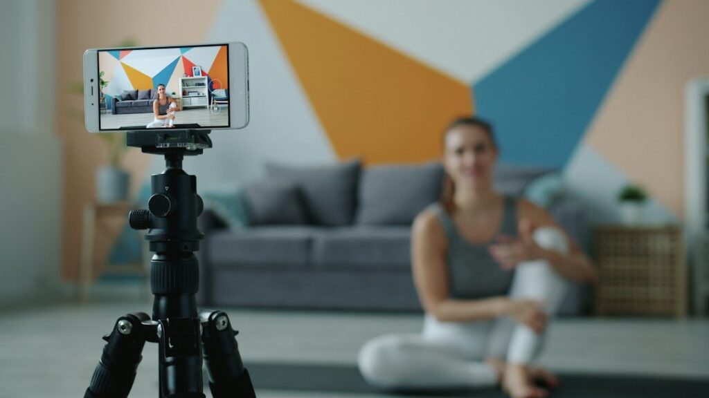 Wellness creator filming a yoga video on a smartphone tripod